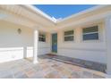 Inviting front porch with tiled floor, white columns, and a blue front door at 136 Reef Rd, South Daytona, FL 32119