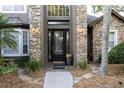 Elegant front door with stone accents and decorative glass, framed by lush landscaping at 1912 Westover Reserve Blvd, Windermere, FL 34786