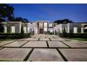 Elegant modern home with symmetrical design, manicured landscaping, and expansive driveway at twilight at 2161 Sharon Rd, Winter Park, FL 32789
