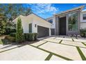 A modern residence showcased with an expansive paved driveway framed by manicured greenery at 2161 Sharon Rd, Winter Park, FL 32789