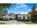 Contemporary home boasting clean lines, a spacious driveway, and lush landscaping under a sunny sky at 2161 Sharon Rd, Winter Park, FL 32789
