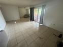 Spacious living room featuring neutral tile floors and sliding glass doors to a patio at 4008 Versailles Dr # 4008C, Orlando, FL 32808