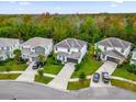 An aerial view of three homes showcasing manicured lawns and private driveways in a lush, green, well-maintained neighborhood at 4571 Cabello Loop, Kissimmee, FL 34746