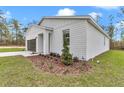 Landscaped front yard with vibrant greenery accentuates the modern home's crisp, white facade at 12220 Sw 76Th Ln, Dunnellon, FL 34432