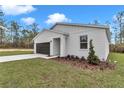 Home with a lush lawn, complemented by a two-car garage and tasteful landscaping at 12220 Sw 76Th Ln, Dunnellon, FL 34432