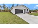 Well-manicured lawn leading up to a one-story home featuring a convenient two-car garage at 12220 Sw 76Th Ln, Dunnellon, FL 34432