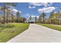A long driveway leads up to this inviting home nestled among mature trees, complemented by a well-kept green lawn at 12386 Sw 89Th St, Dunnellon, FL 34432