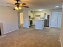 Bright living room featuring carpet, ceiling fan, fireplace, and open concept to a modern kitchen at 485 Forestway Cir # 202, Altamonte Springs, FL 32701