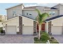 Well-maintained townhomes with stone accents, two car garages, red doors, and manicured lawns at 953 Splash Shot Pl # 953, Davenport, FL 33896