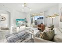Bright living room with neutral tones, modern light fixture, and sliding glass doors to balcony at 953 Splash Shot Pl # 953, Davenport, FL 33896