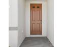 An inviting front door with decorative panels is framed by a neutral stucco exterior at 1324 Oak Valley Dr, Auburndale, FL 33823