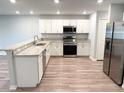Well-lit kitchen with white cabinets, granite countertops, and stainless steel appliances at 2906 Fieldwood Cir, St Cloud, FL 34772