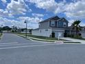 Corner lot home featuring well-manicured landscaping, a two-car garage, and an inviting exterior design at 247 Villavista Ct, Davenport, FL 33896