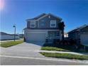Two-story home with a two-car garage, complemented by a lush green lawn and a charming exterior at 247 Villavista Ct, Davenport, FL 33896