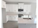Bright kitchen featuring white cabinets, stainless steel appliances, and a large center island with sink and counter space at 576 Pothos St, Apopka, FL 32703