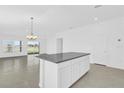 Modern kitchen featuring a large granite island, recessed lighting, and open access to living space at 1792 Aurora Oak Ln, Sanford, FL 32771