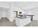 Bright kitchen featuring white cabinetry, stainless steel appliances, and a large granite island at 1792 Aurora Oak Ln, Sanford, FL 32771