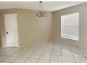 Bright living room featuring tile floors, neutral paint, window overlooking a green outdoor space and modern light fixture at 2708 Smithfield Dr, Orlando, FL 32837