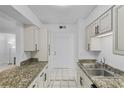 Bright kitchen features granite countertops, stainless steel sink, white cabinets, and modern black hardware at 525 Conway Rd # 167, Orlando, FL 32807