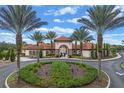 Attractive community entrance with lush landscaping and palm trees at 7420 Oakmoss Loop, Davenport, FL 33837