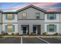 Townhouse with blue shutters and a well maintained lawn and property at 7420 Oakmoss Loop, Davenport, FL 33837