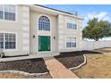 Close up on a two-story home featuring a green door, trimmed windows, and front yard landscaping at 800 Daybreak Dr, Fruitland Park, FL 34731