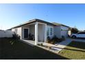 Attractive single-story home featuring a covered porch, landscaped garden, and a paved driveway at 881 Orchid Grove Blvd, Davenport, FL 33837