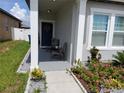 Cozy front porch with seating and a charming wreath on the front door at 881 Orchid Grove Blvd, Davenport, FL 33837