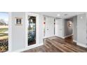 Bright entryway with a modern white front door, wood floors, and natural light from an adjacent window at 647 Ridgewood Dr, Windermere, FL 34786