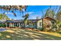 Green house with stone accents, spacious lawn, and mature trees at 647 Ridgewood Dr, Windermere, FL 34786