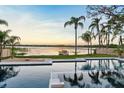 Relaxing backyard showcasing a luxurious pool with waterfront views and lush landscaping, perfect for enjoying serene sunsets at 1340 Susannah Blvd, Orlando, FL 32803