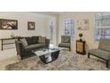 Living room featuring a gray couch, coffee table, and accent chairs at 1402 Olympic Club Blvd, Champions Gate, FL 33896