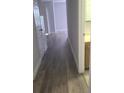 Inviting hallway featuring wood-style flooring and neutral paint, leading to various rooms at 3946 Versailles Dr # 3946B, Orlando, FL 32808