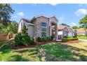 Beautiful home featuring a mix of brick and stucco, enhanced by well-kept landscaping and lush green lawn at 2226 Lake Marion Dr, Apopka, FL 32712