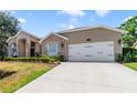Well-maintained home exterior showcasing a spacious driveway and a two-car garage with an attached brick-accented facade at 2226 Lake Marion Dr, Apopka, FL 32712