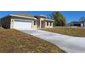 Lovely tan single-Gathering home with a two-car garage and a paved driveway amidst a green lawn at 4655 Sw 139Th Ln, Ocala, FL 34473
