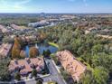 Stunning aerial view of townhomes with a central pond and fountain, nestled in lush greenery and foliage at 1300 Gilford Point Ln # 1300, Davenport, FL 33896