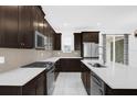 Modern kitchen featuring stainless steel appliances, dark wood cabinets, and white marble countertops at 2097 Celebration Blvd, Celebration, FL 34747