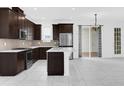 Spacious kitchen featuring stainless steel appliances, dark wood cabinets, a kitchen island and tile floors at 2097 Celebration Blvd, Celebration, FL 34747
