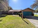 Ranch style home with teal garage door and brick facade at 3021 Norvell Ct, Deltona, FL 32738