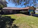 Brick ranch home with a teal garage door and a landscaped lawn at 3021 Norvell Ct, Deltona, FL 32738