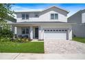 Charming two-story home with manicured lawn, brick driveway, and inviting front porch seating at 159 Golden Noble St, Kissimmee, FL 34747