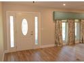 Bright entryway with a decorative door and light wood flooring at 306 Wild Olive Ln, Longwood, FL 32779