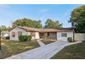 Front yard view of a ranch style home with a long driveway at 1748 Haverhill Dr, Deltona, FL 32725