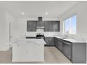 Modern kitchen with gray cabinetry, marble countertops, and a center island with a breakfast bar at 528 Carya Way, Auburndale, FL 33823