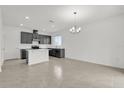 Open-concept kitchen features dark cabinets, an island with a countertop, and tile flooring at 528 Carya Way, Auburndale, FL 33823