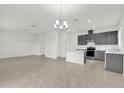 Spacious kitchen area with tile flooring, complete with a modern island and stylish chandelier at 528 Carya Way, Auburndale, FL 33823
