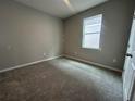 This carpeted bedroom provides neutral walls, a bright window, and a white door at 5298 Teirgarten St, St Cloud, FL 34771