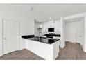Modern kitchen featuring white cabinetry, black countertops, and sleek appliances at 367 Sequoia Dr, Lake Wales, FL 33859
