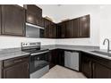 Modern kitchen featuring stainless steel appliances, granite countertops, and dark wood cabinets at 375 Sequoia Dr, Lake Wales, FL 33859